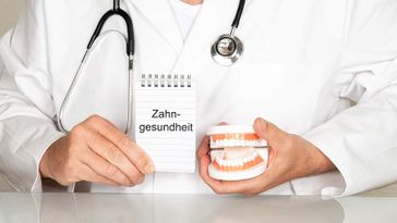 Arzt mit Schild Zahngesundheit
